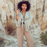 Woman standing against a sandy background, looking at the camera wearing Ambarya Strength - Hematite Mala Bead Set