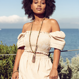 Woman standing with beach in background wearing Ambarya Harmony - Unakite mala bead set