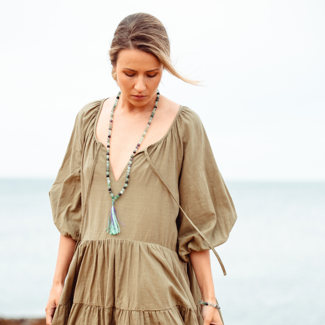 Woman looking down wearing Clarity - Rainbow Fluorite Mala Bead Necklace