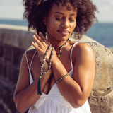 Woman sitting in the sun with her eyes closed wearing Ambarya Good health - Bloodstone Mala Bead Set