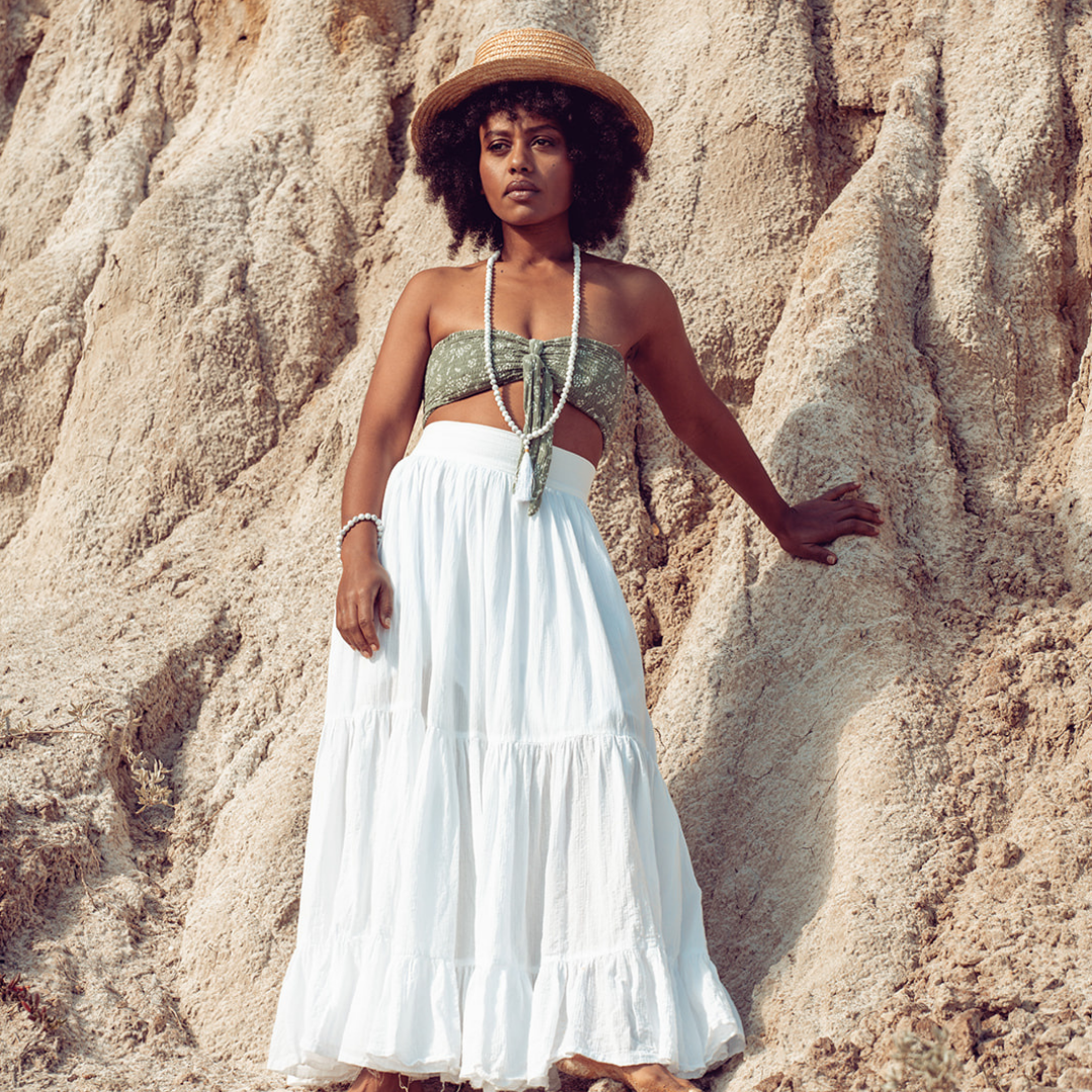 Woman looking into the distance, standing against rocks she is wearing Ambarya Patience - Howlite Mala Bead Set