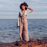Woman smiling and standing on rocks near water wearing Ambarya Release - Smoky Quartz Mala Bead Set